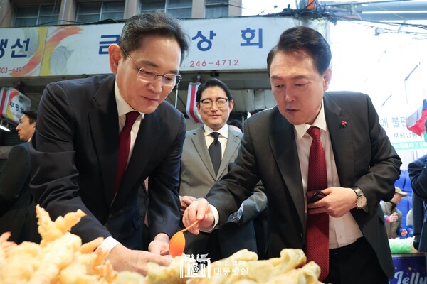6일 부산의 대표 전통시장인 국제시장을 찾은 윤석렬 대통령이 이재용 회장에게 시식 음식을 건네고 있다. 사진=대통령실